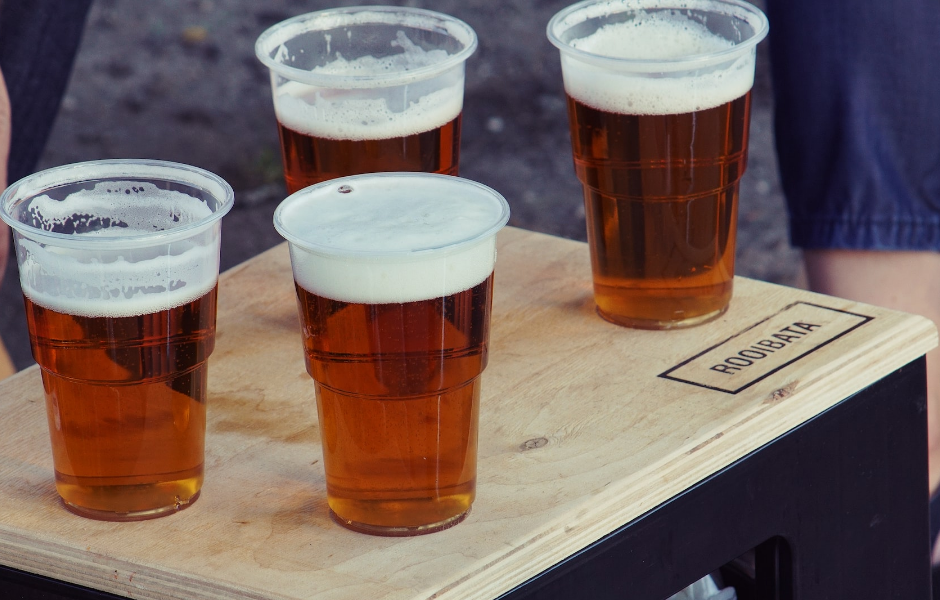 a number of beers in plastic cups